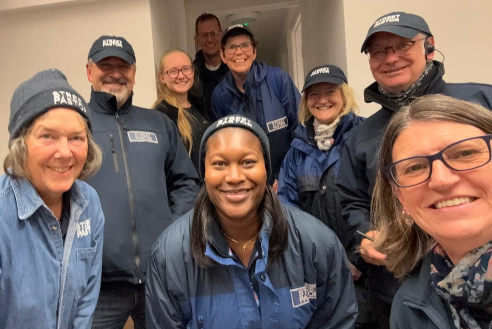 A group of people in Street Pastors hats and jackets